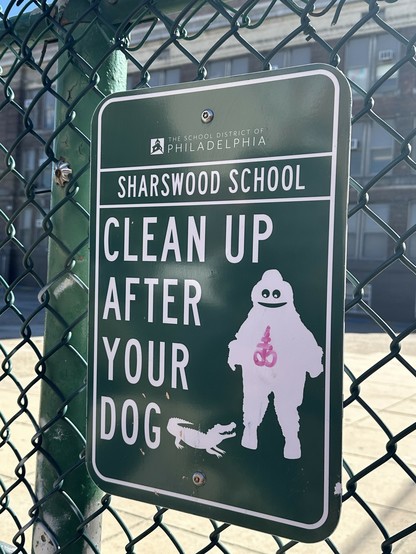 very official looking CLEAN UP AFTER YOUR DOG sign screwed to a fence but it's got gritty with a pet alligator. also someone drew the luciferian/sulphur symbol on gritty. Ave satanas