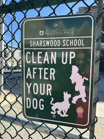 very official looking CLEAN UP AFTER YOUR DOG sign screwed to a fence but it's shaggy and Scooby doo