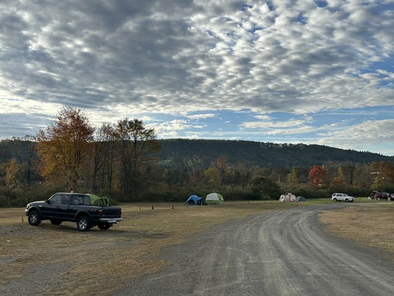 Poconos mountains under a big frickin cloudy blue sky. there's a few other tents nearby 