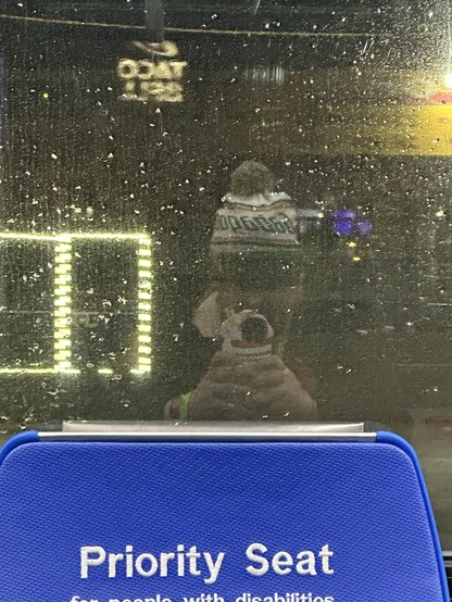 me in my Gabagool hat reflected in the window across from me on da bus