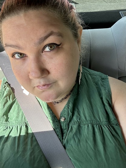 me sitting in a car and my eyes are shiny cuz of the sunlight and they kinda match my dress which is cool