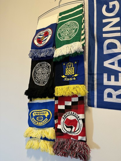 football scarves on a hanger - reading, celtic, brondby, grorud, clapton