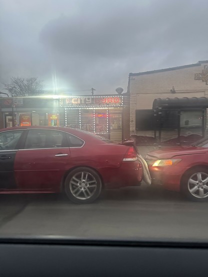 there's two red cars connected by a blanket between the trunk and the hood and I am baffled