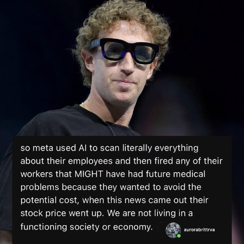 A medium close-up photograph of a person with curly hair wearing thick glasses, overlaid with white text on a dark semi-transparent box. The individual has light brown curly hair and is wearing black-framed eyeglasses and a black shirt against a blurred dark background. The text in the overlay reads: "so meta used AI to scan literally everything about their employees and then fired any of their workers that MIGHT have had future medical problems because they wanted to avoid the potential cost, when this news came out their stock price went up. We are not living in a functioning society or economy." In the bottom right corner of the text box is a small circular profile icon next to the username "aurorabrittrva".